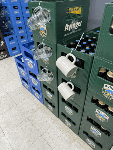 crates of ayinger beer are stacked on top of each other in a store