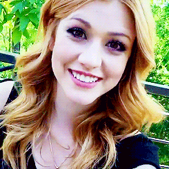 a woman with blonde hair is smiling and wearing a black shirt