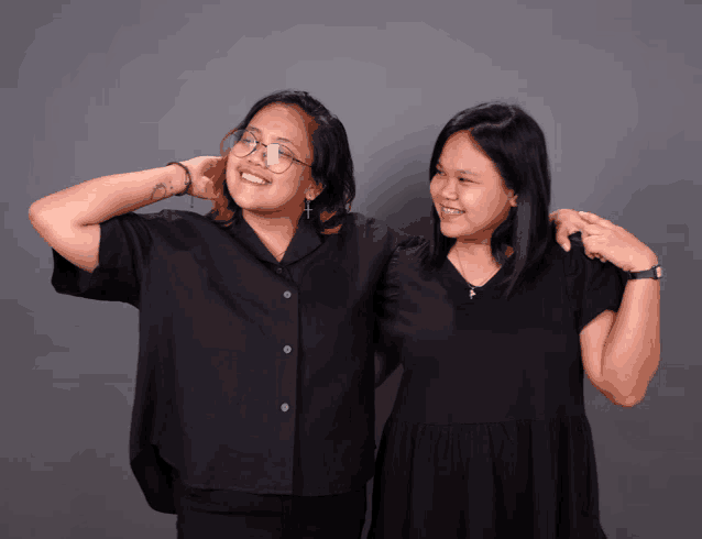 two women are posing for a picture and one has a tattoo on her arm that says ' i love you '