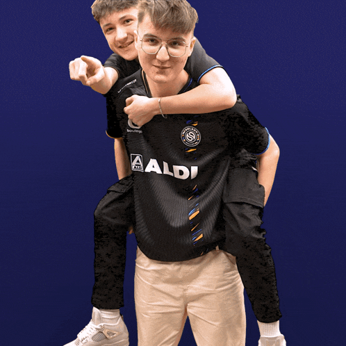 a man wearing a black aldi shirt is carrying another man