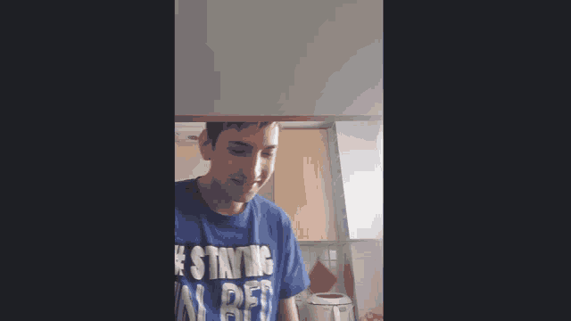 a man wearing a blue shirt that says staying a def