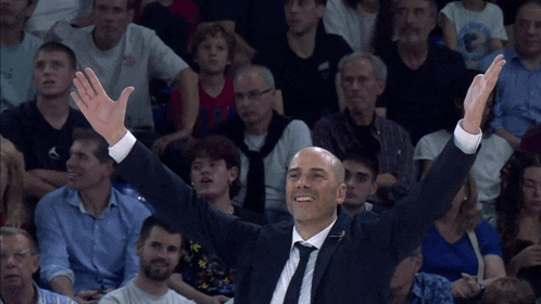 a man in a suit and tie with his arms in the air