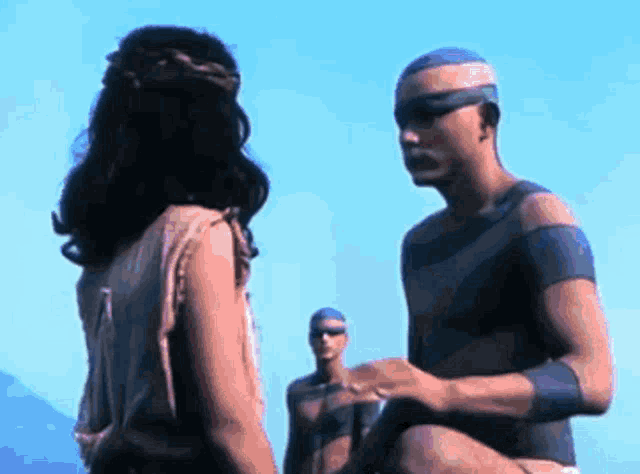 a man and a woman are standing next to each other and talking .
