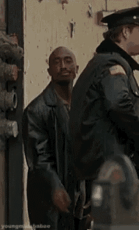 a man in a leather jacket is standing next to a police officer