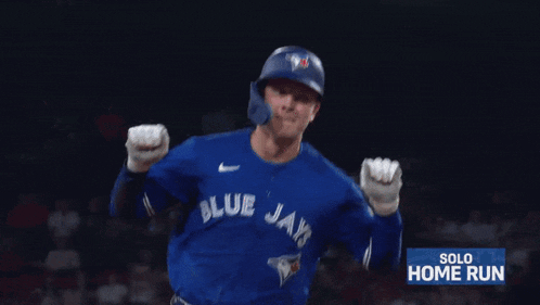 a baseball player for the blue jays runs towards home plate