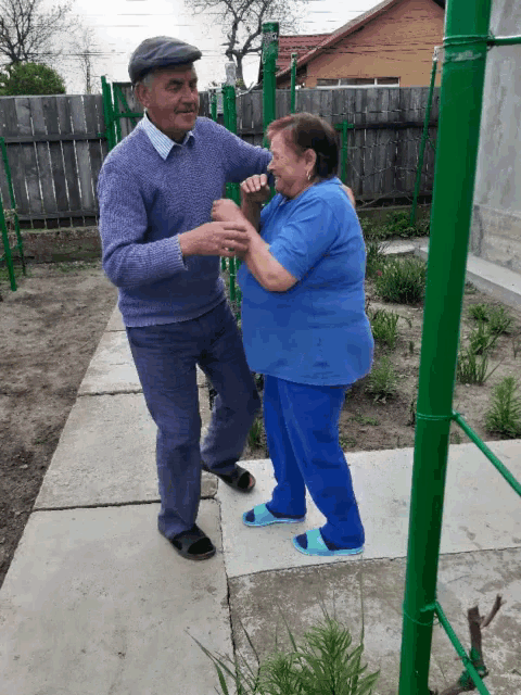 a man and a woman are dancing on a sidewalk