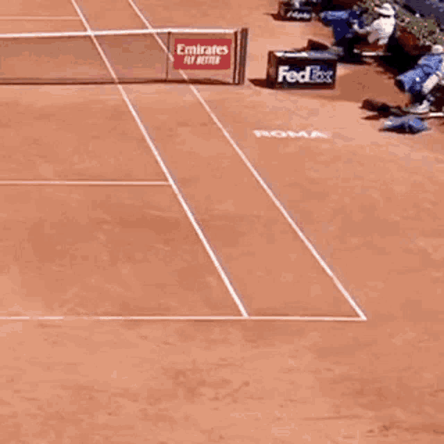 a man playing tennis on a court with a fedex sign in the background