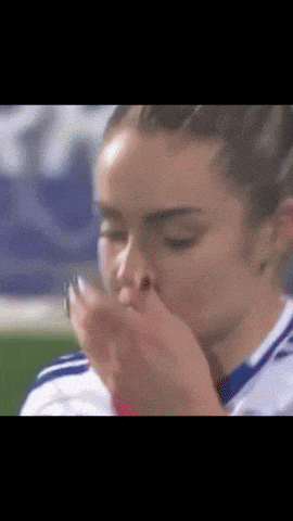 a close up of a woman blowing a kiss