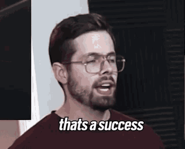 a man with a beard and glasses is making a funny face and saying `` that 's a success '' .