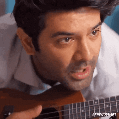 a close up of a man playing a guitar with the words barunsobigifs above him