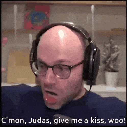 a bald man wearing glasses and headphones says " c'mon judas give me a kiss woo "
