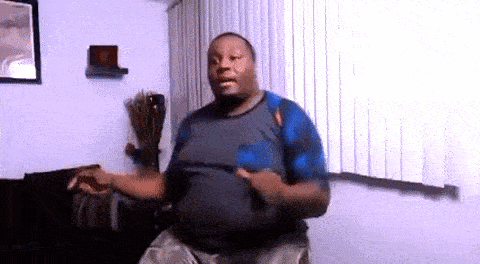 a man is dancing in a living room in front of a couch and window .