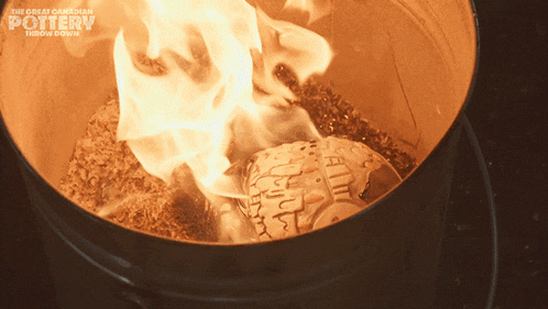 the great canadian pottery throw down shows a fire burning in a barrel
