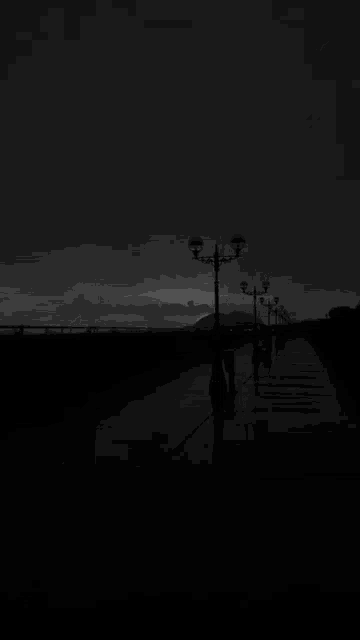 a black and white photo of a lightning strike on a pier