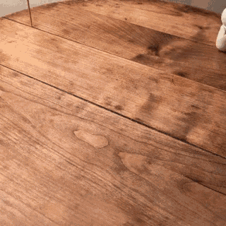 a close up of a wooden table with a white object on it
