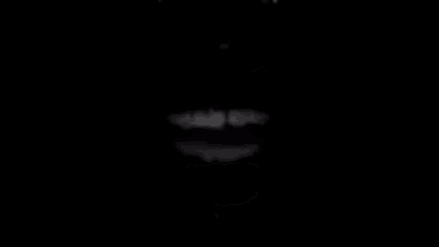 a close up of a person 's mouth and teeth in the dark