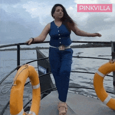 a woman standing on a boat with pinkvilla written on the bottom