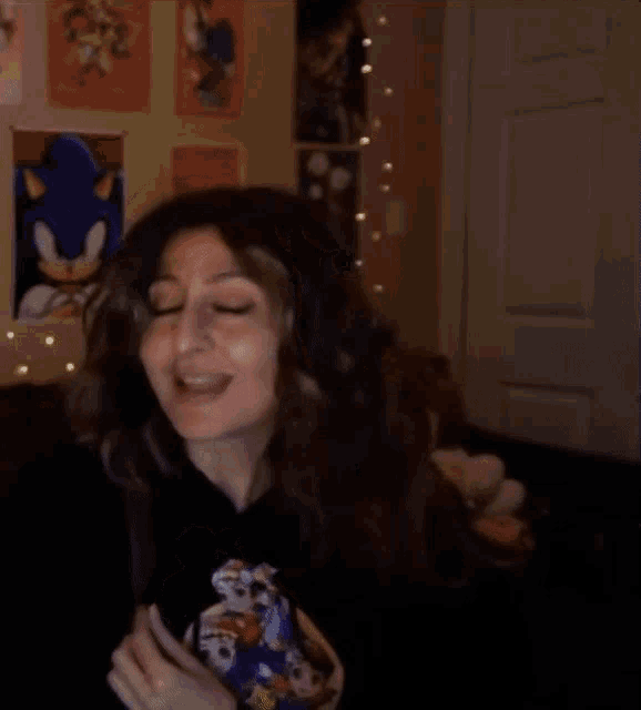 a woman wearing a sonic the hedgehog shirt is covering her mouth with her hands
