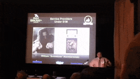 a man stands at a podium giving a presentation about service providers under $1 m