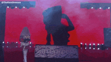a woman in a white bra is dancing on a stage with the words " the glamour " mariah may