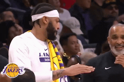 a man wearing a headband and a lakers shirt is clapping