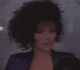 a close up of a woman 's face with curly hair