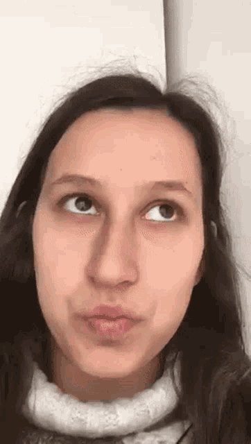 a woman is making a funny face with her eyes closed and her mouth open .