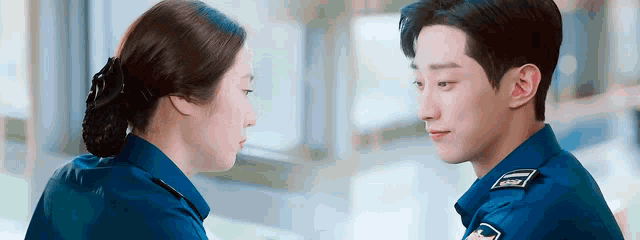 a man and a woman are looking at each other in a police uniform .