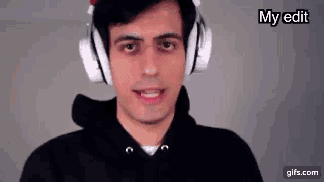 a man wearing headphones and a black hoodie is making a face .