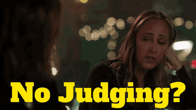 a woman sitting next to another woman with the words " no judging " behind her
