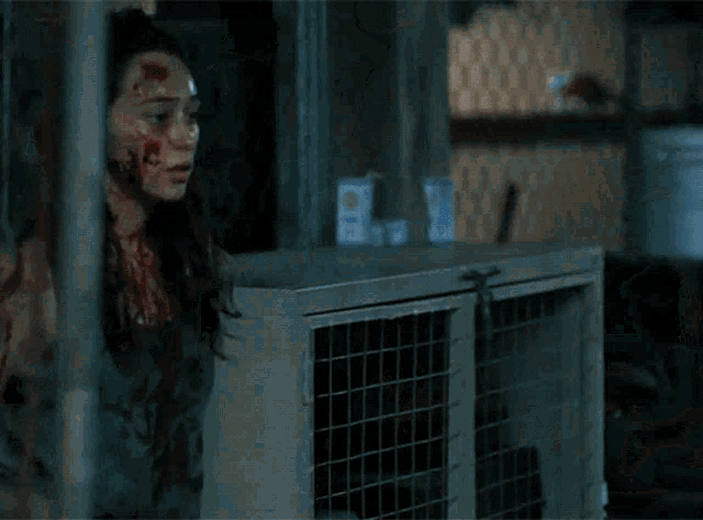 a woman with blood on her face is standing in a room