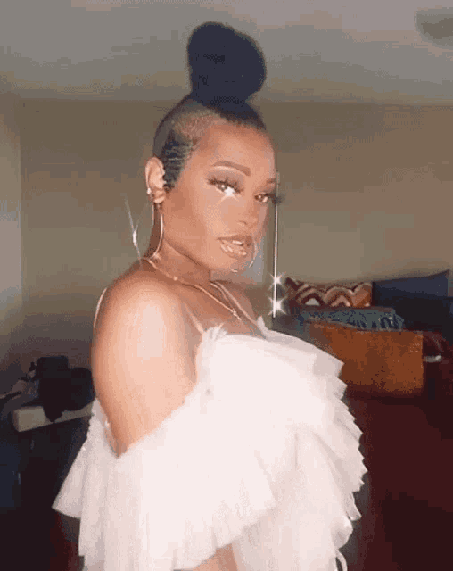 a woman is wearing a white off the shoulder top