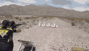 a woman is shooting a gun with the number 47 on her shirt