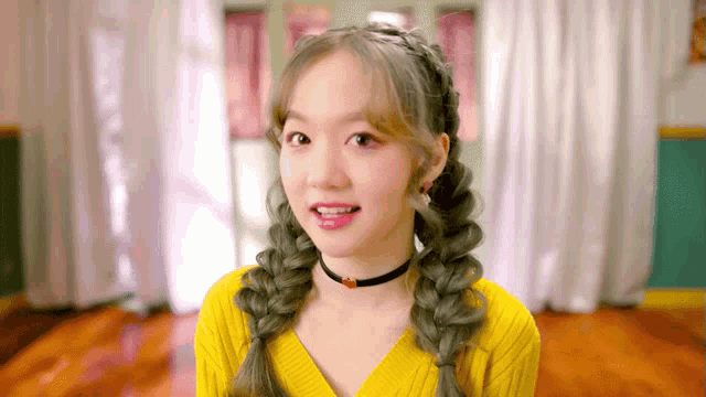 a girl in a yellow sweater has braids in her hair and a choker around her neck