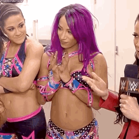 a female wrestler with purple hair is being interviewed by a woman in a microphone .