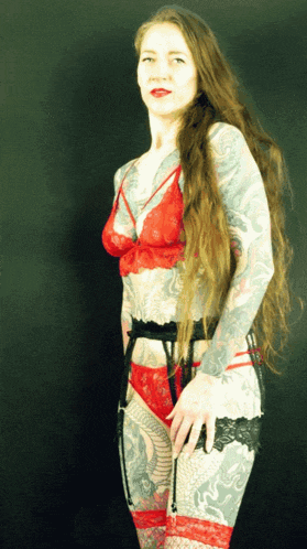 a woman with a lot of tattoos is wearing red and black lingerie