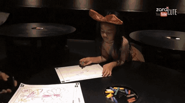 a little girl wearing a cowboy hat is drawing on a piece of paper with the words zara cute on the bottom