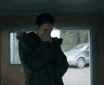 a person wearing a black jacket with a furry hood