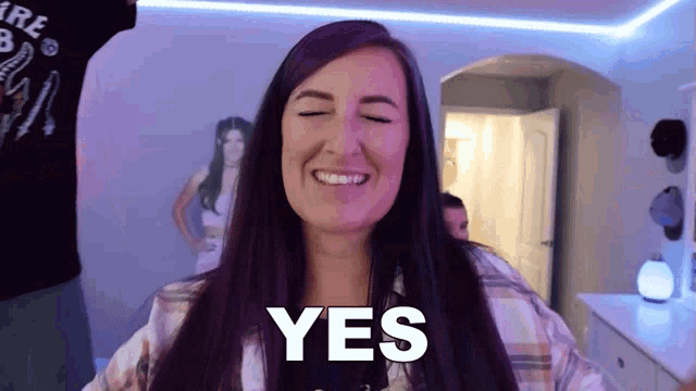 a woman with purple hair is smiling and the word yes is on her face