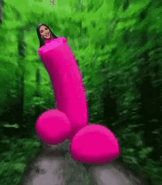 a woman is wrapped in a pink penis in a forest .