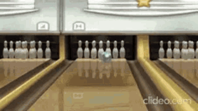 a bowling alley with pins and a ball going to the pins
