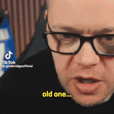 a man wearing glasses says " old one " in a video