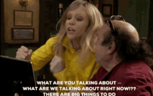 a man and a woman are sitting at a table talking to each other