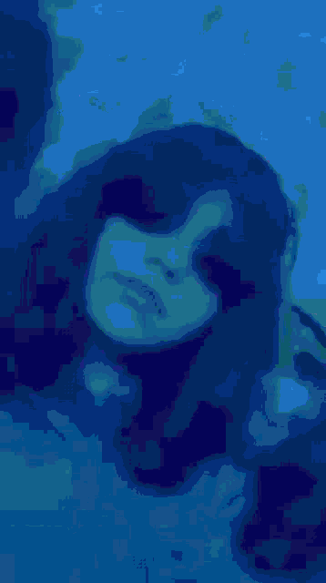 a blurry picture of a person 's face with blue hair