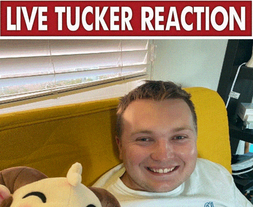 a man is laying on a yellow couch with a stuffed animal and a sign that says live tucker reaction