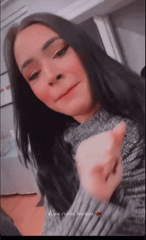 a woman wearing a grey sweater with the words " esos caros buenos " written on the bottom