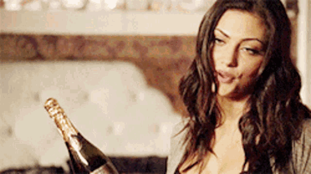 a woman is holding a bottle of champagne in her hands