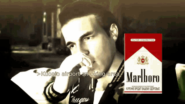 a man smoking a pack of marlboro cigarettes in a black and white photo