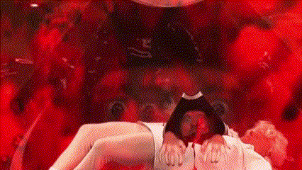 a man is laying on a woman 's lap in a red room with a devil in the background .