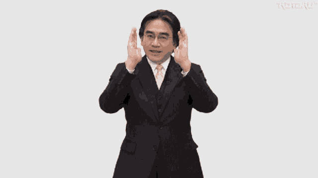 a man in a suit and tie is making a gesture that says direct to you